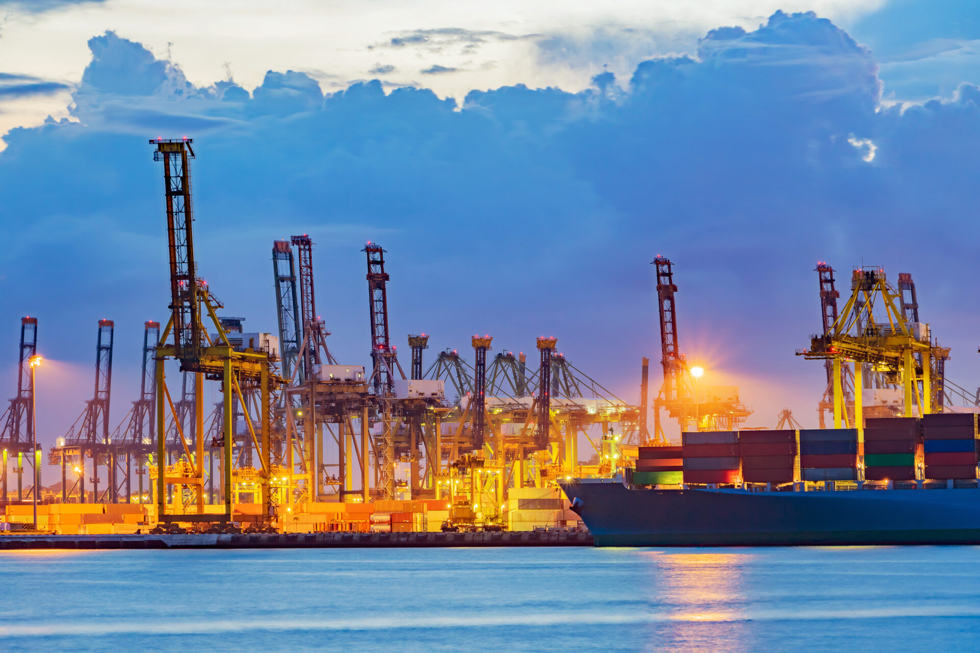 Freighter,Ship,Loading,Cargo,At,Loading,Dock,On,Twilight,Time.