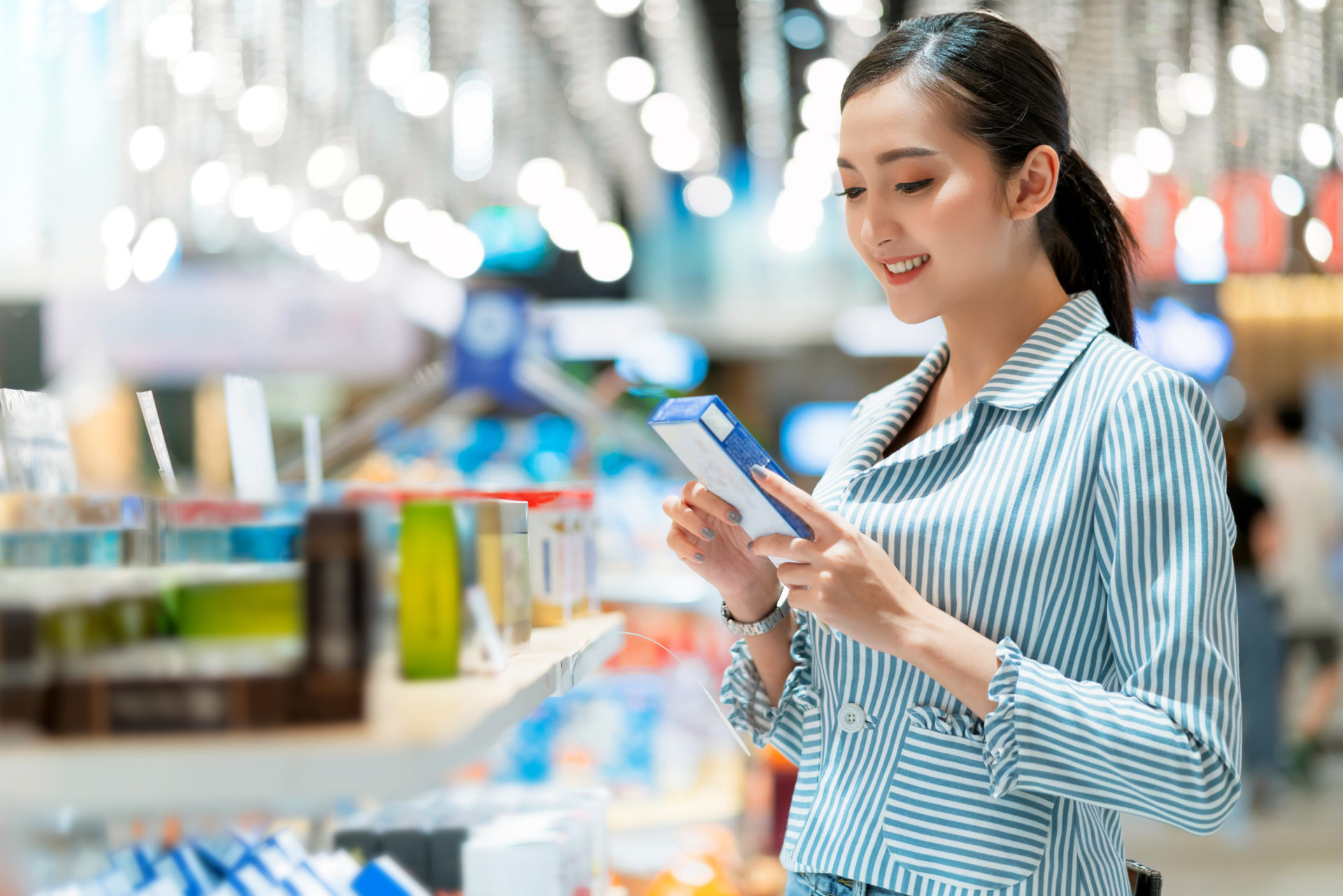 asian attractive female shopping with happiness and cheerful on supermarket blur mall bokeh background,oung Asian woman with cart grocery shopping for fresh produce